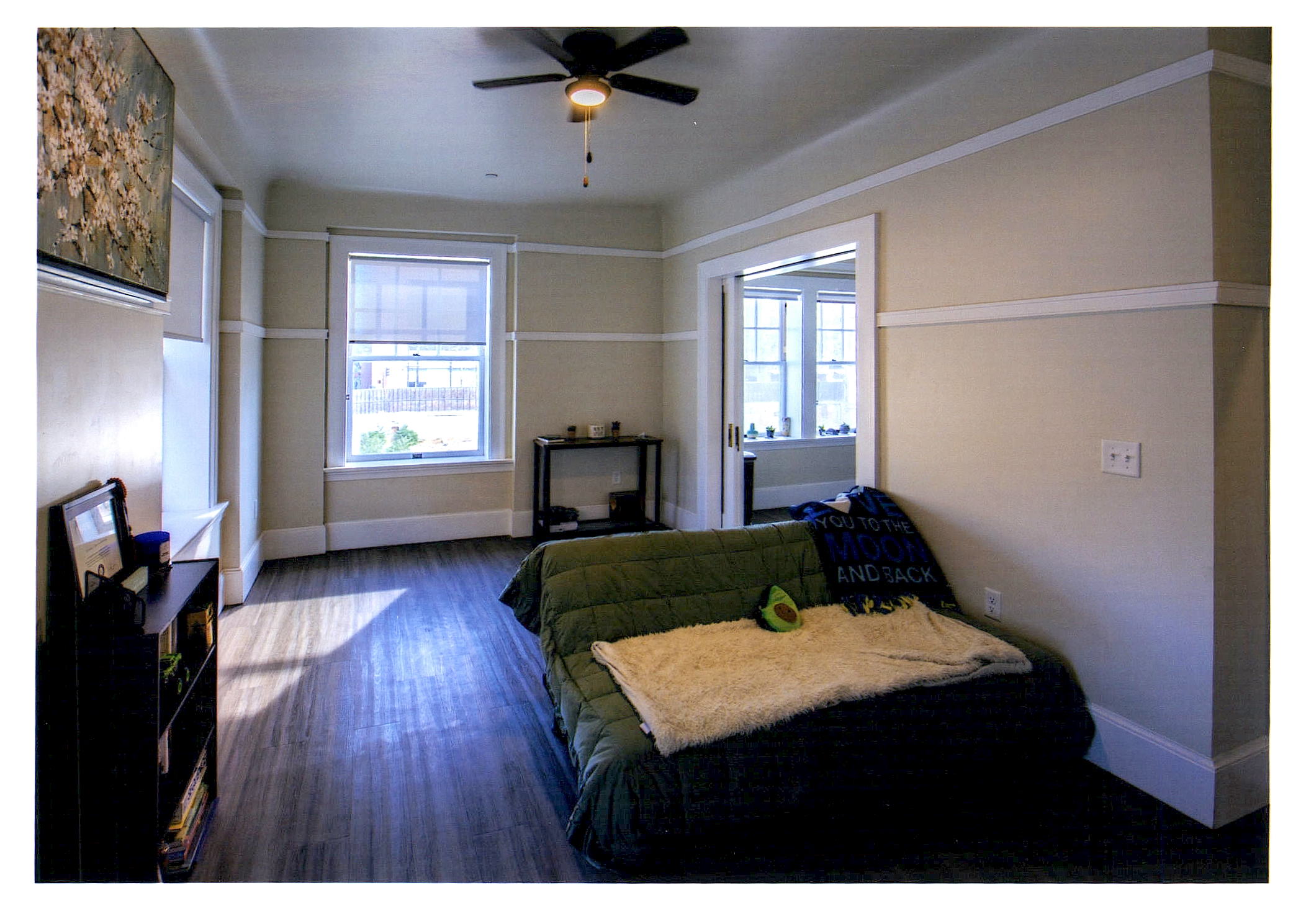 After: view of bedroom area looking towards windows. Living area beyond paired sliding doors is to the right.